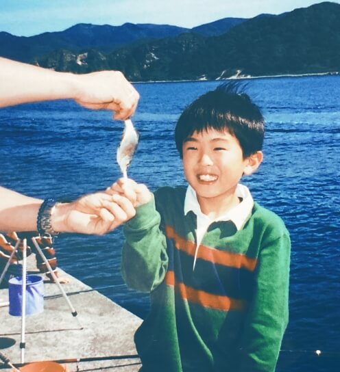 子どもの頃の釣った魚を見せる写真